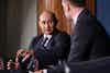 a man in a suit talking to another man
