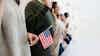 Immigration line with people holding American flag