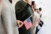 Immigration line with people holding American flag