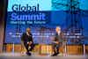 two men sitting in chairs talking