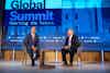 two men sitting in chairs on a stage
