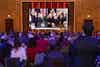 a group of people sitting in chairs in front of a large screen