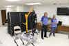 a man and woman standing in a room with a robot