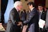 two men shaking hands in a room